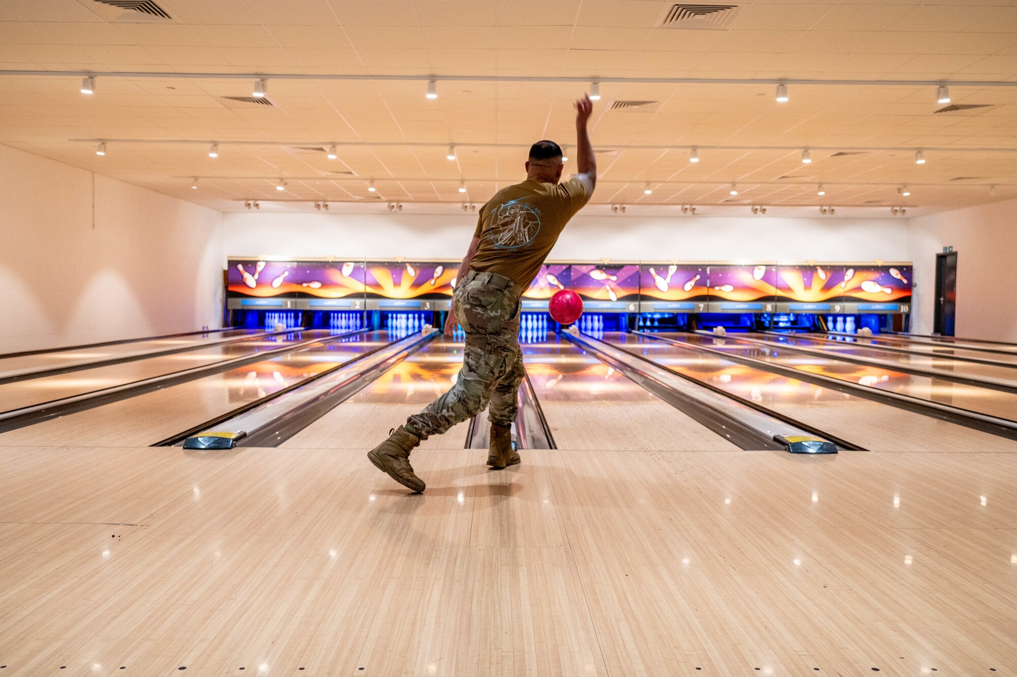 An Airman releases a bowling ball