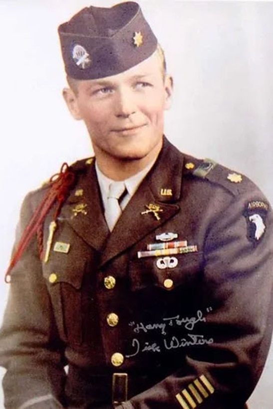 A uniformed soldier smiles for a photo.