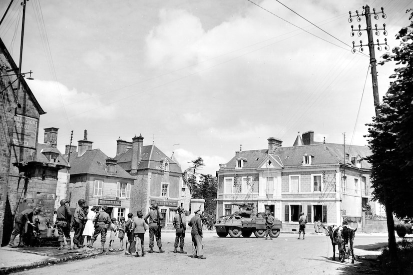 People in town talk with service members.