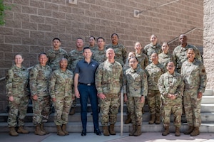 The Honorable Alex Wagner, Assistant Secretary of the Air Force for Manpower and Reserve Affairs, and Chief Master Sgt. of the Air Force David Flosi, pose for a group photo with Airmen during a visit to Nellis Air Force Base, Nevada, May 7, 2024.
