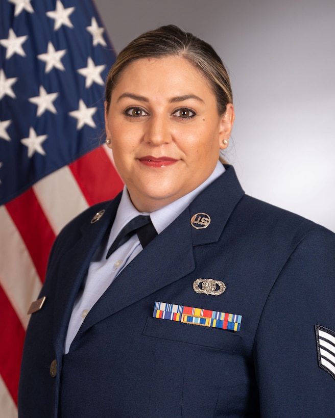 Official photo of SSgt Danielle Headrick with American flag over right shoulder