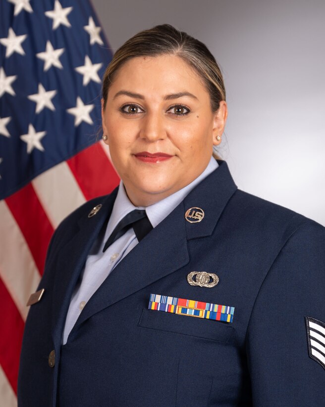 Official photo of SSgt Danielle Headrick with American flag over right shoulder