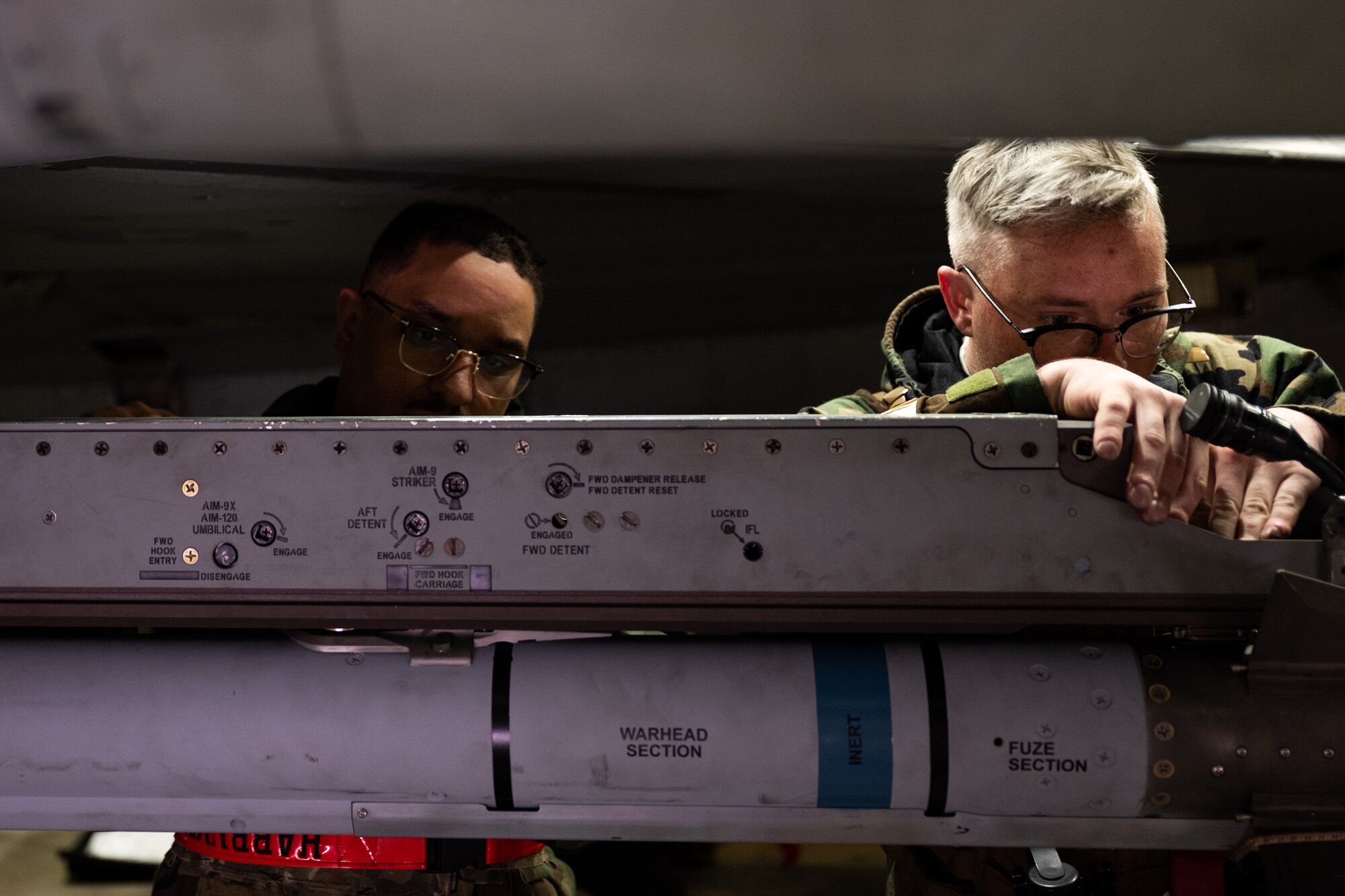 U.S. Air Force Staff Sgt. Darian Betancourt (left) and Senior Airman Nathan Davis, 36th Fighter Generation Squadron weapons load crew chief and crew member, cross load a missile during Beverly Herd 24-1 at Osan Air Base, Republic of Korea, May 15, 2024. The Airmen of the 51st Fighter Wing continuously train to maintain the high level of full-spectrum readiness required to execute the mission proficiently and effectively. Routine training events like Beverly Herd are pivotal platforms for 51st Fighter Wing Airmen to refine their warfighting proficiencies through practical application, concurrently enhancing their ability to respond skillfully to contingencies. (U.S. Air Force photo by Tech. Sgt. Clayton Lenhardt)