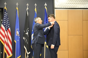 Darrell Phillipson, director of AFRL’s Materials and Manufacturing Directorate, presents Dr. Mark Benedict with the senior executive pin during a ceremony to mark his induction into the Scientific and Professional Cadre of Senior Executives at Wright-Patterson Air Force Base, May 9, 2024. Benedict officially accepted the role of senior scientist for convergent (digital) manufacturing at the Air Force Research Laboratory, or AFRL’s, Materials and Manufacturing Directorate in February.
U.S. Air Force photo / Sarah Perez