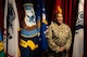 U.S. Army Soldier poses in front of flags at her promotion ceremony