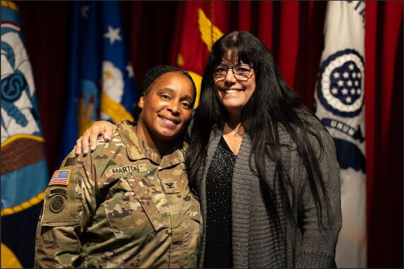 Female U.S. Army Soldier poses with friend after promotion ceremony