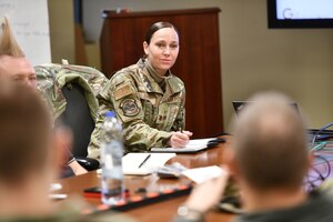 Major listens at a conference table