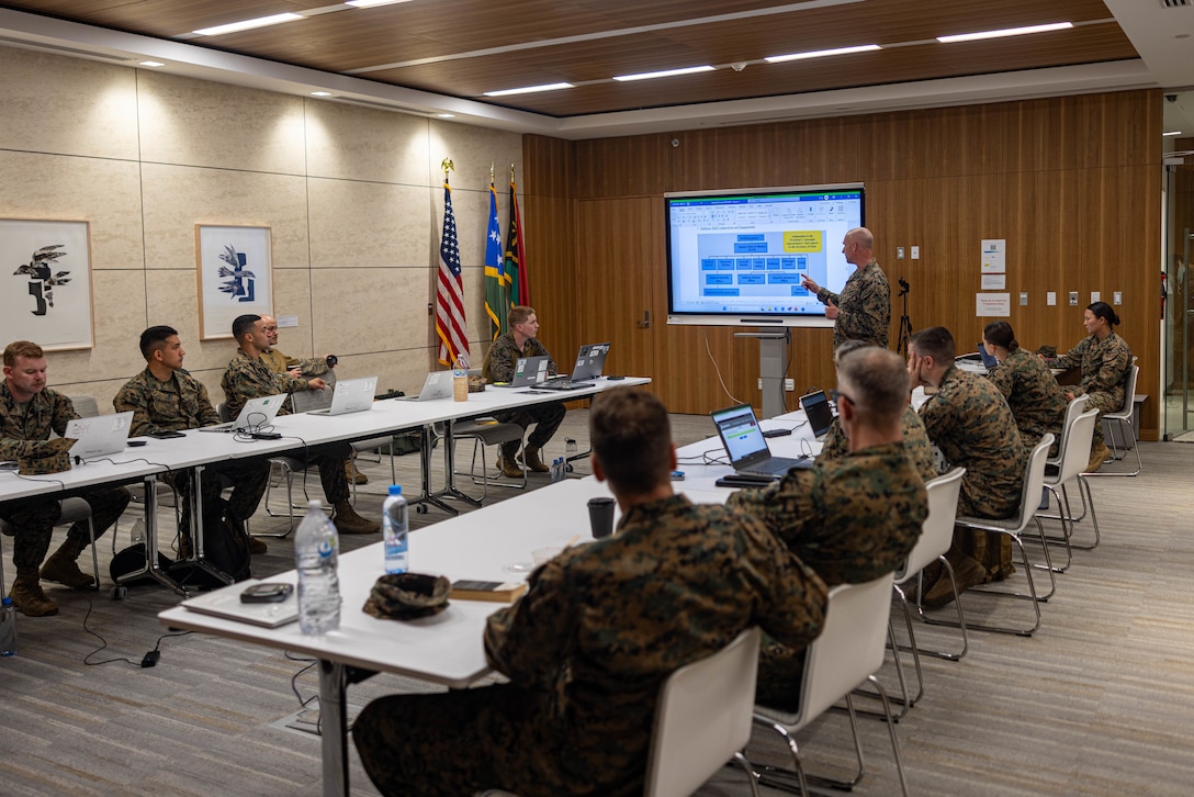 U.S. Marine Corps Lt. Col. Scott Stafford, top, the executive officer of Marine Rotational Force – Darwin 24.3, briefs the MRF-D 24.3 forward command element during a table top exercise as part of a humanitarian assistance and disaster relief exercise at the U.S. Embassy, Port Moresby, Papua New Guinea, May 2, 2024. The HADR exercise is conducted in coordination with the Papua New Guinea Defence Force and U.S. Embassy in Port Moresby, with a focus on projecting select role II medical, logistics, and Marine Air-Ground Task Force command and control capabilities off-continent, to validate HADR training and readiness. Stafford is a native of Indiana. (U.S. Marine Corps photo by Cpl. Juan Torres)