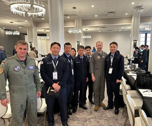 Military members from different countries pose for a group photo.