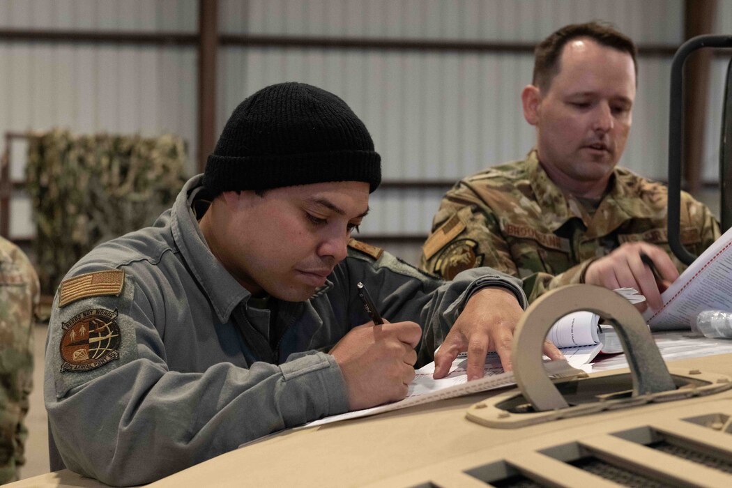 Airmen inspect Humvee prior to loading on an aircraft.