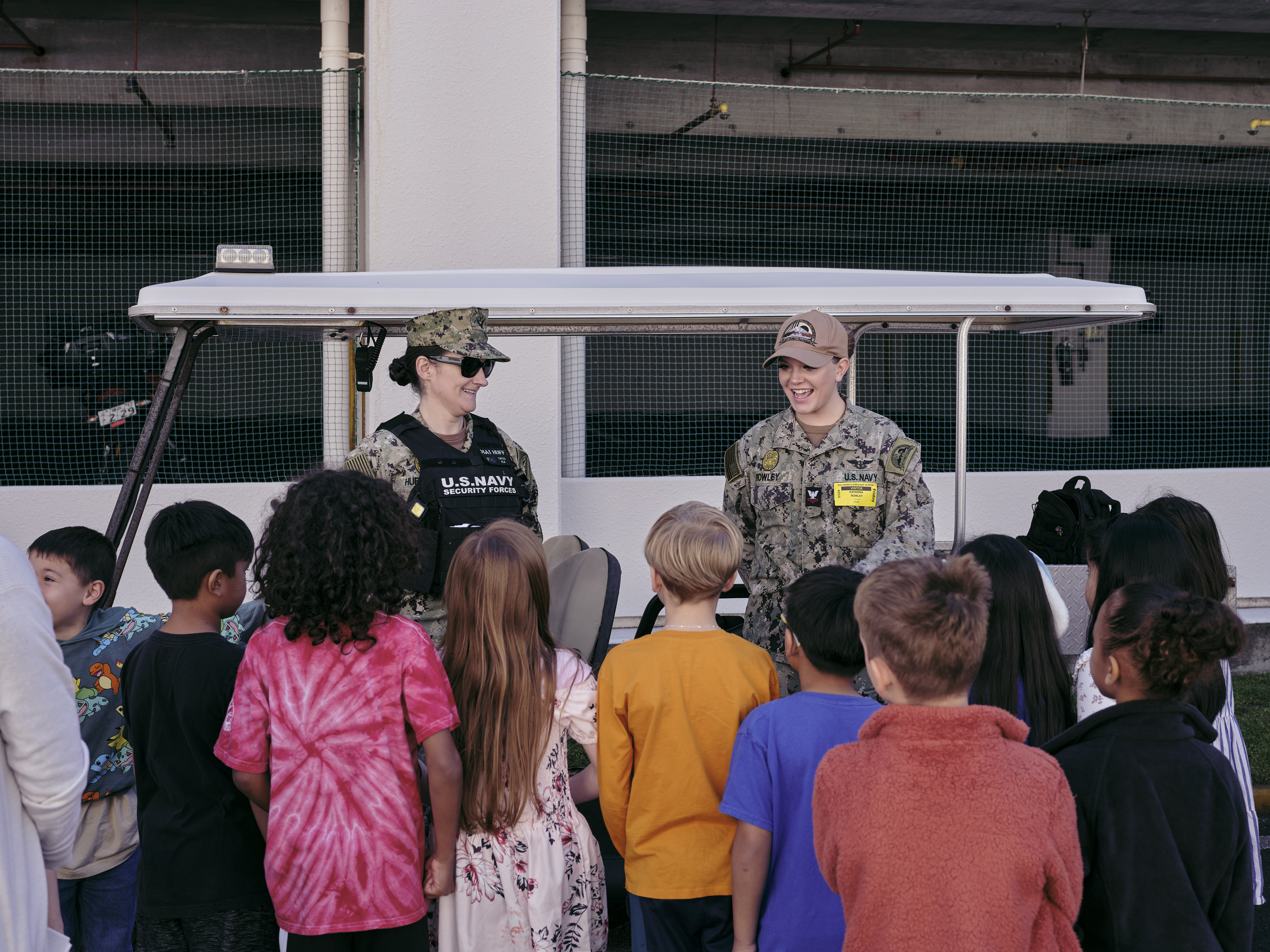 Master-at-Arms 2nd Class Katarina Rowley (right) and Master-at-Arms 1st Class Mandi Huffaker (left), take questions from students about his job during The Sullivans Elementary School's first Car Career Day Friday, May 3, 2024 in Yokosuka, Japan.