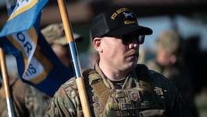 Senior Master Sgt. Todd Pluff carries a Defenders’ flag during a ruck march for Police Week.