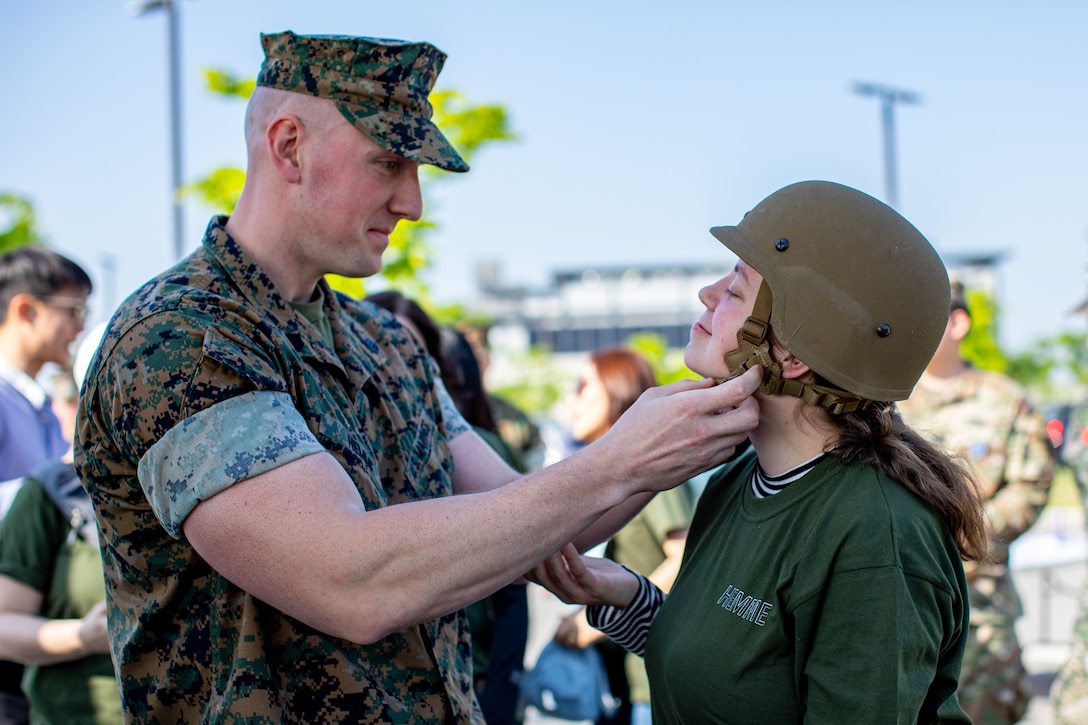 U.S. Marine Corps Staff Sgt. Jonathan Hemme, a career planner with U.S. Marine Corps Forces Korea, places personal protective equipment on his spouse during Jayne Wayne day at U.S. Army Garrison Humphreys, South Korea, May 3, 2024. Jayne Wayne day strengthens camaraderie and gives spouses a more solid understanding of what their service member does daily and builds intercultural bonds. (U.S. Marine Corps photo by Cpl. Dean Gurule)