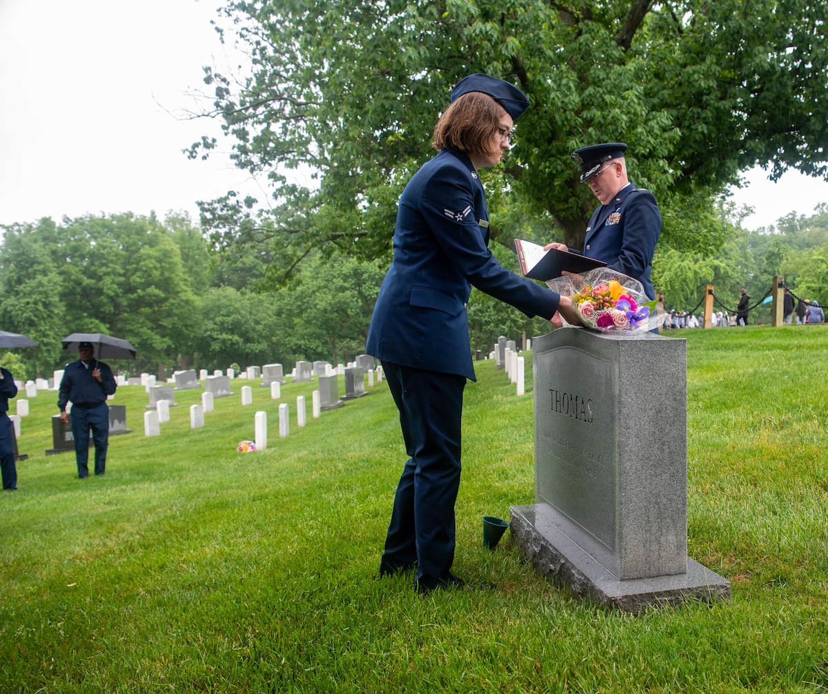 Airman 1st Class Julia Asmus, 436th Airlift Wing religious affairs, places flowers on a grave at Arlington National Cemetery in Arlington, Va., May 10, 2024
