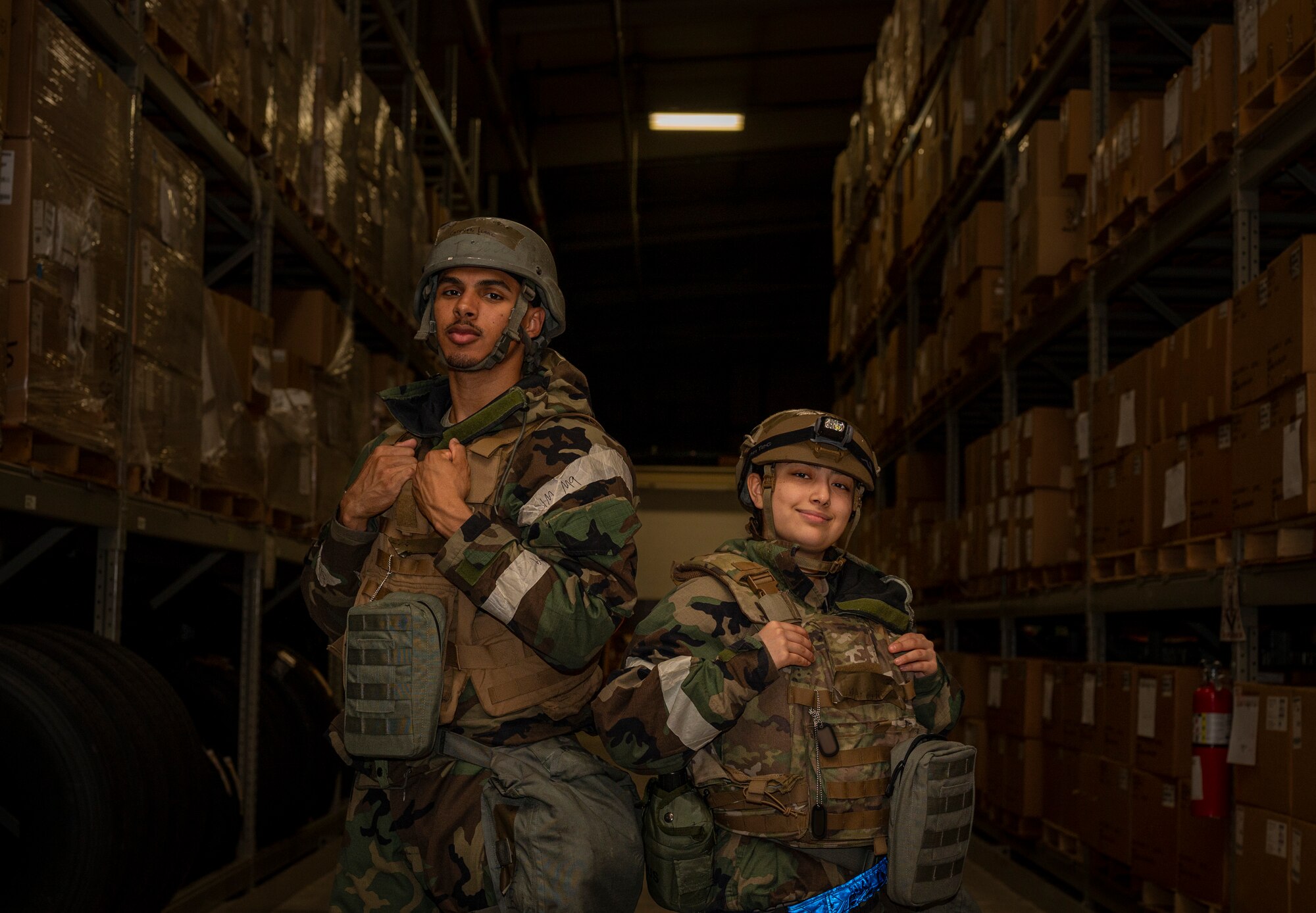 U.S. Air Force Senior Airman Isaac Groves, left, 51st Logistics Readiness Squadron individual protection equipment journeyman, and Airman 1st Class Arlene Martinez, 51st LRS central storage journeyman, pose for a portrait for contingency training events during Beverly Herd 24-1 at Osan Air Base, Republic of Korea, May 16, 2024. The 51st LRS ensures that base personnel are equipped with the necessary supplies and gear to remain combat-ready. Routine training events like Beverly Herd are pivotal platforms for 51st Fighter Wing Airmen to refine their warfighting proficiencies through practical application, concurrently enhancing their ability to respond skillfully to contingencies. (U.S. Air Force photo by Senior Airman Sabrina Fuller-Judd)