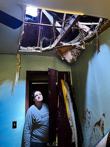 A a resident of Chester, West Virginia, peers through a roof damaged by a tornado, May 10, 2024, in Chester, West Virginia. The system was declared a high end EF-2 tornado with it's winds reaching 130 mph. (U.S. Air Force photo by Senior Master Sgt. Maranda Jordan)