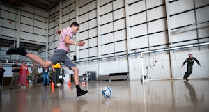 A Joan Mann Special Sports Day athlete kicks a soccer ball toward a goal defended by U.S. Air Force Col. Ryan Garlow, 100th Air Refueling Wing commander, at Royal Air Force Mildenhall, England, May 9, 2024.