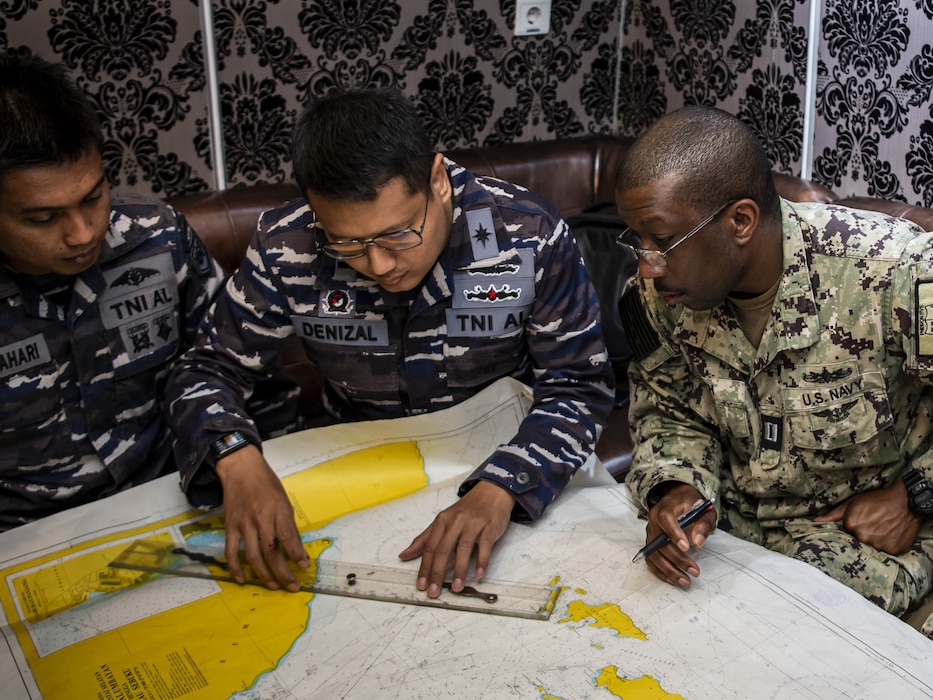 U.S. and Indonesian navy leaders review a chart during a planning briefing aboard the Indonesian navy fast attack craft Kri Kerambit-627 during CARAT Indonesia 2024.