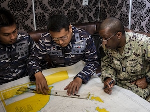 U.S. and Indonesian navy leaders review a chart during a planning briefing aboard the Indonesian navy fast attack craft Kri Kerambit-627 during CARAT Indonesia 2024.