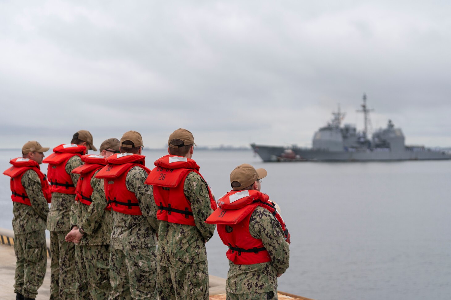 A formation of Sailors standby to assist the guided-missile cruiser USS Leyte Gulf (CG 55) return to Naval Station Norfolk, May 17, 2024, marking their final deployment.