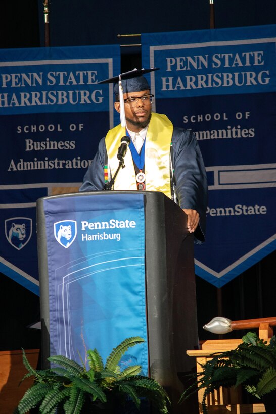 U.S. Army Sgt. Ashon Calhoun, a public affairs specialist with the 109th Mobile Public Affairs Detachment, 213 Regional Support Group, Pennsylvania National Guard, gives a commencement speech during the Penn State Harrisburg 2024 graduation ceremony at the Giant Center at Hershey, Pennsylvania, May 4, 2024. Calhoun graduated summa cum laude, was his class marshal and was selected as the only student speaker during the ceremony. (Courtesy Photo by Sharon Siegfried)