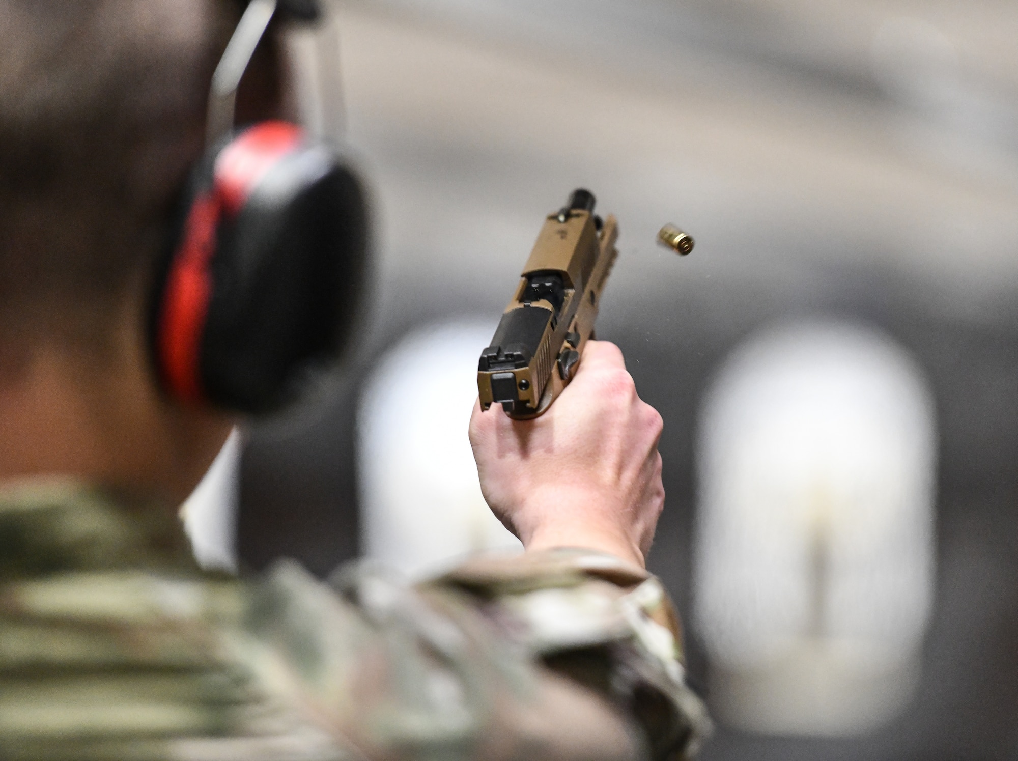 Airman fires a pistol at a target