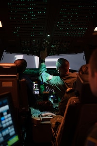 Maj. Bryant Burns, a pilot with the 157th Operations Group, prepares the KC-46 simulator with Col. Domingos Correia, director of national defense and a pilot for the Cabo Verde Armed Forces, during a base tour May 7, 2024, at Pease Air National Guard Base in Newington, N.H.