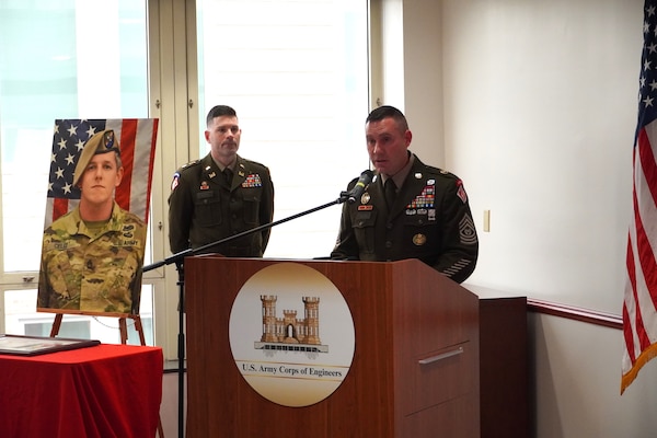 USACE Command Sgt Major Douglas Galik stands behind a podium while delivering remarks at a De Fleury Ceremony honoring Sergeant First Class Christopher A. Celiz