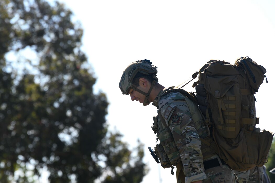 Airman resting with ruck pack prior to ruck march
