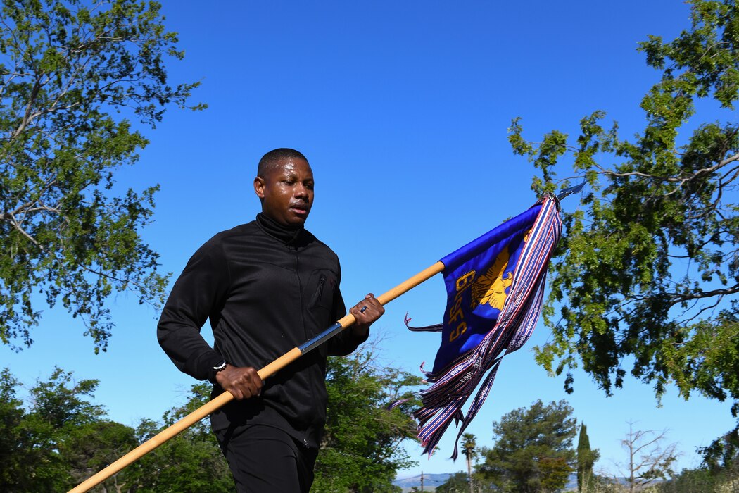 Airman carrying a squadron guide-on during a ruck march