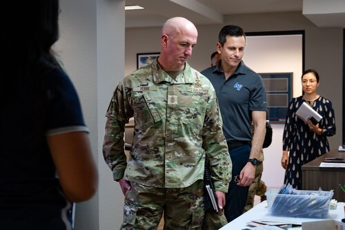 A man in a military uniform looks down at a table.