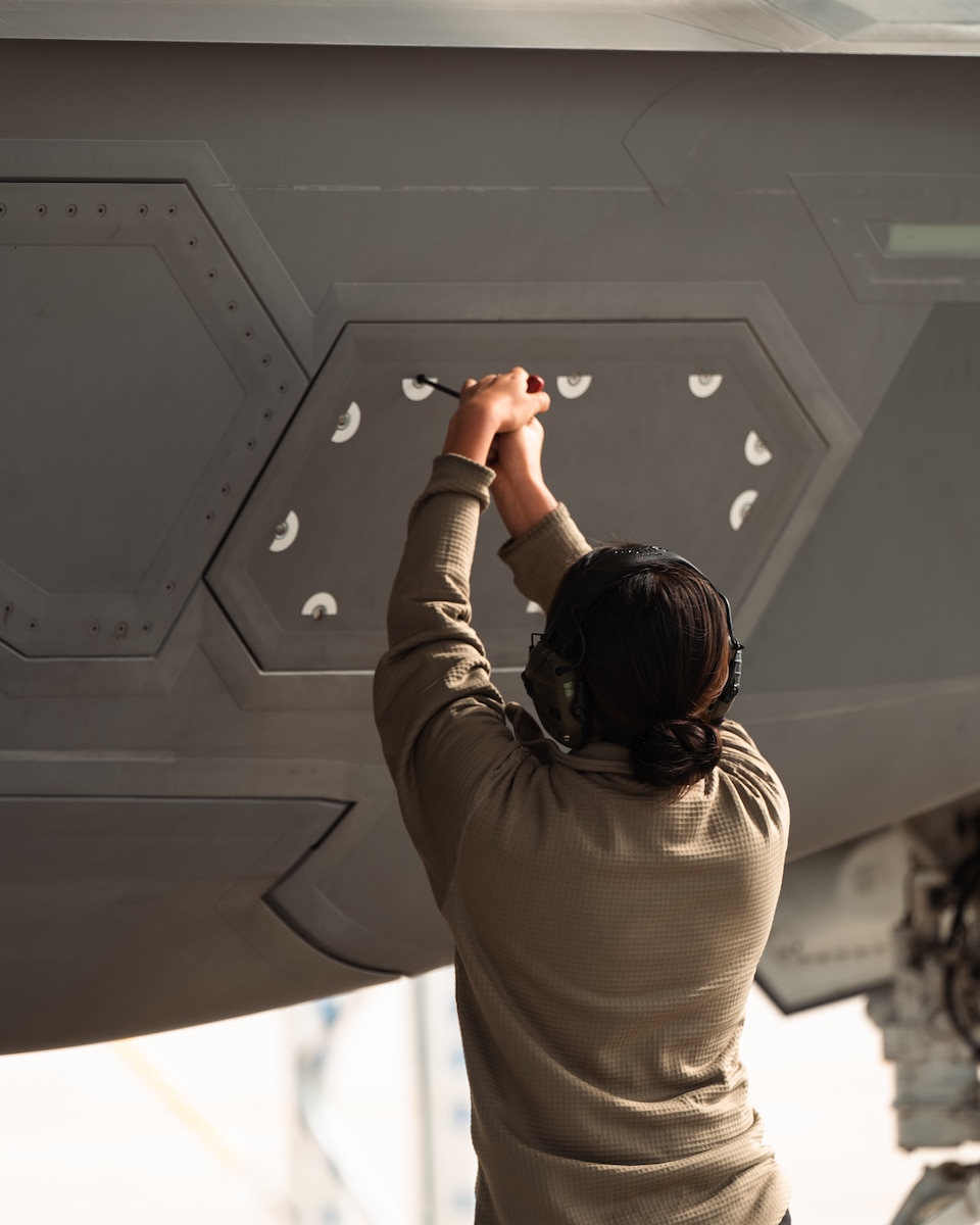 aircraft maintainer closes panel on aircraft