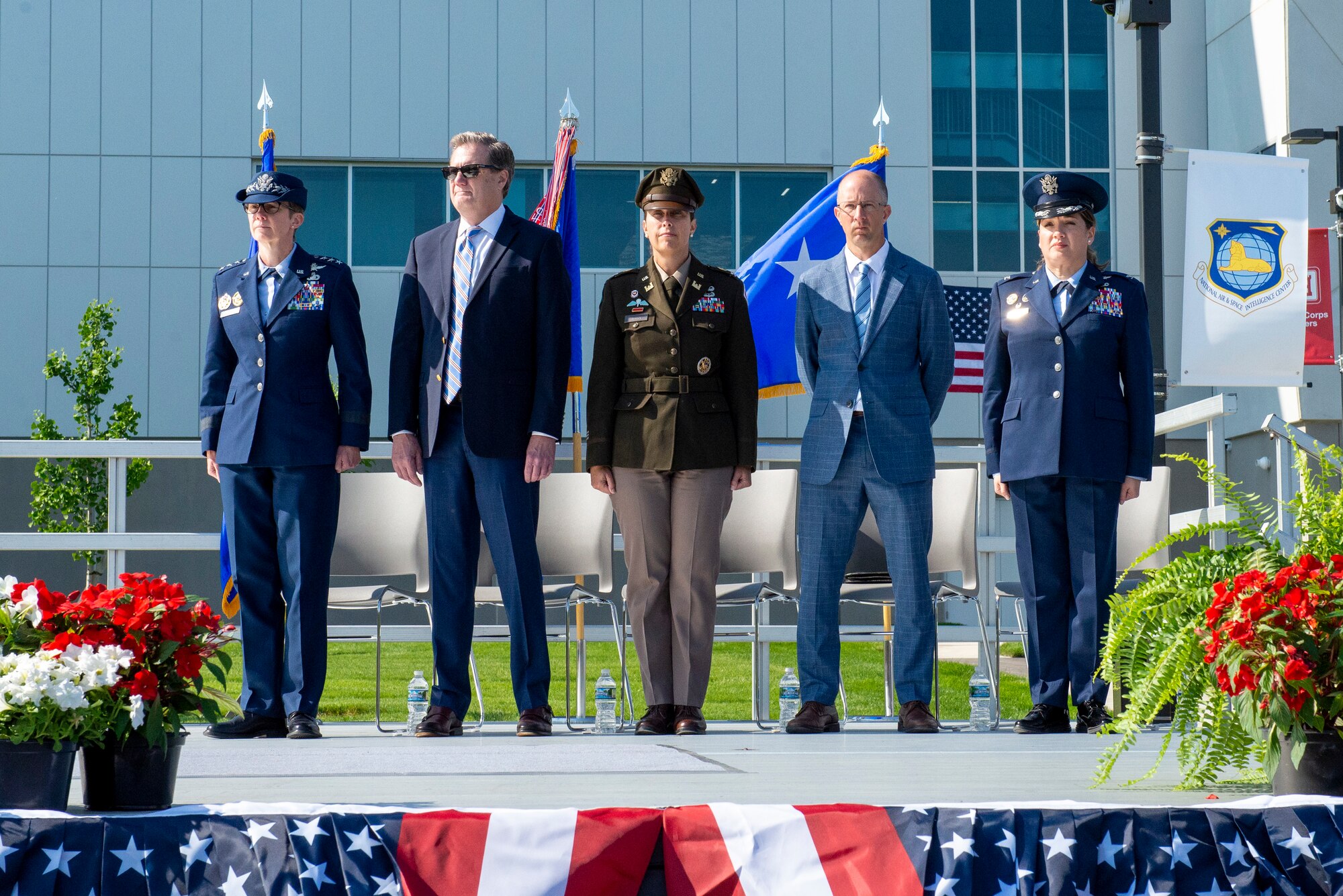 Five people standing while colors are being presented.