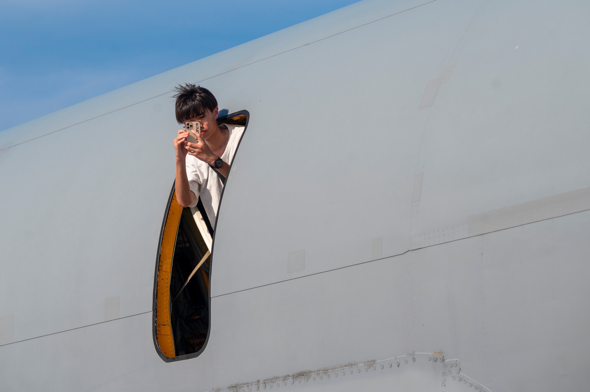 An off-base community member takes a photo out the window of a KC-135 Stratotanker assigned to the 909th Air Refueling Squadron at the 2024 Japanese-American Friendship Festival at Yokota Air Base.