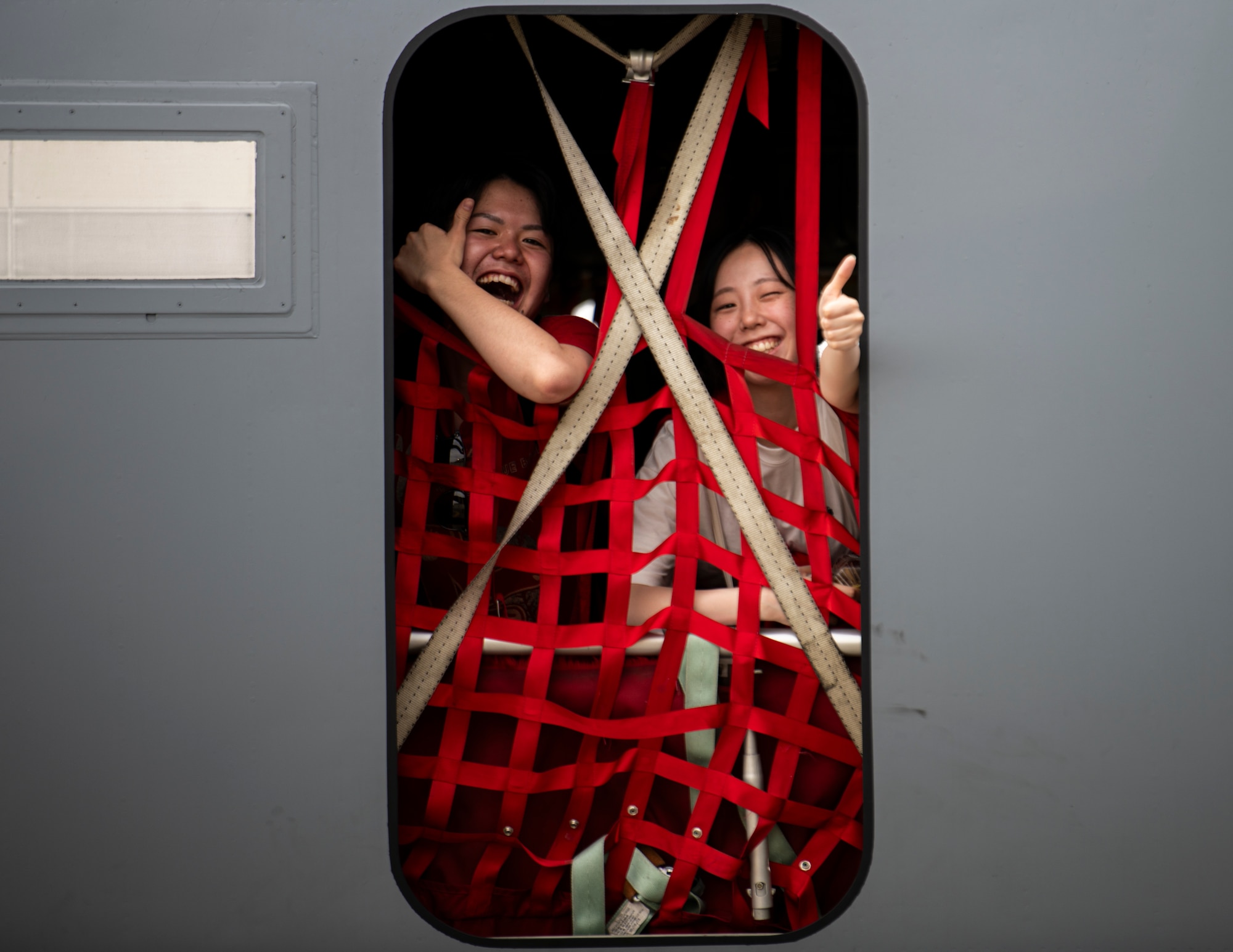 Visitors pose for a photo through the troop door of a C-130J Super Hercules assigned to the 36th Airlift Squadron during the 2024 Japanese-American Friendship Festival at Yokota Air Base.