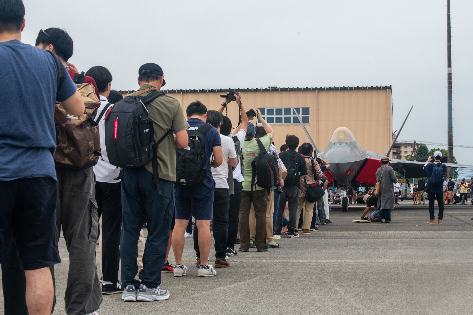 A line of visitors by the F-22 Raptor static display
