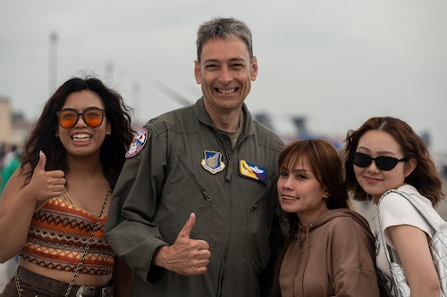 U.S. Air Force Col. Andrew Roddan, 374th Airlift Wing commander, poses for a photo with off-base community members during the 2024 Japanese-American Friendship Festival at Yokota Air Base.