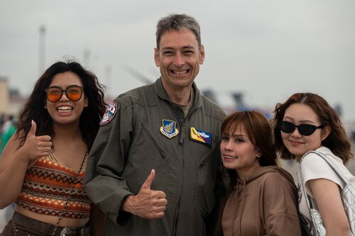 U.S. Air Force Col. Andrew Roddan, 374th Airlift Wing commander, poses for a photo with off-base community members during the 2024 Japanese-American Friendship Festival at Yokota Air Base.
