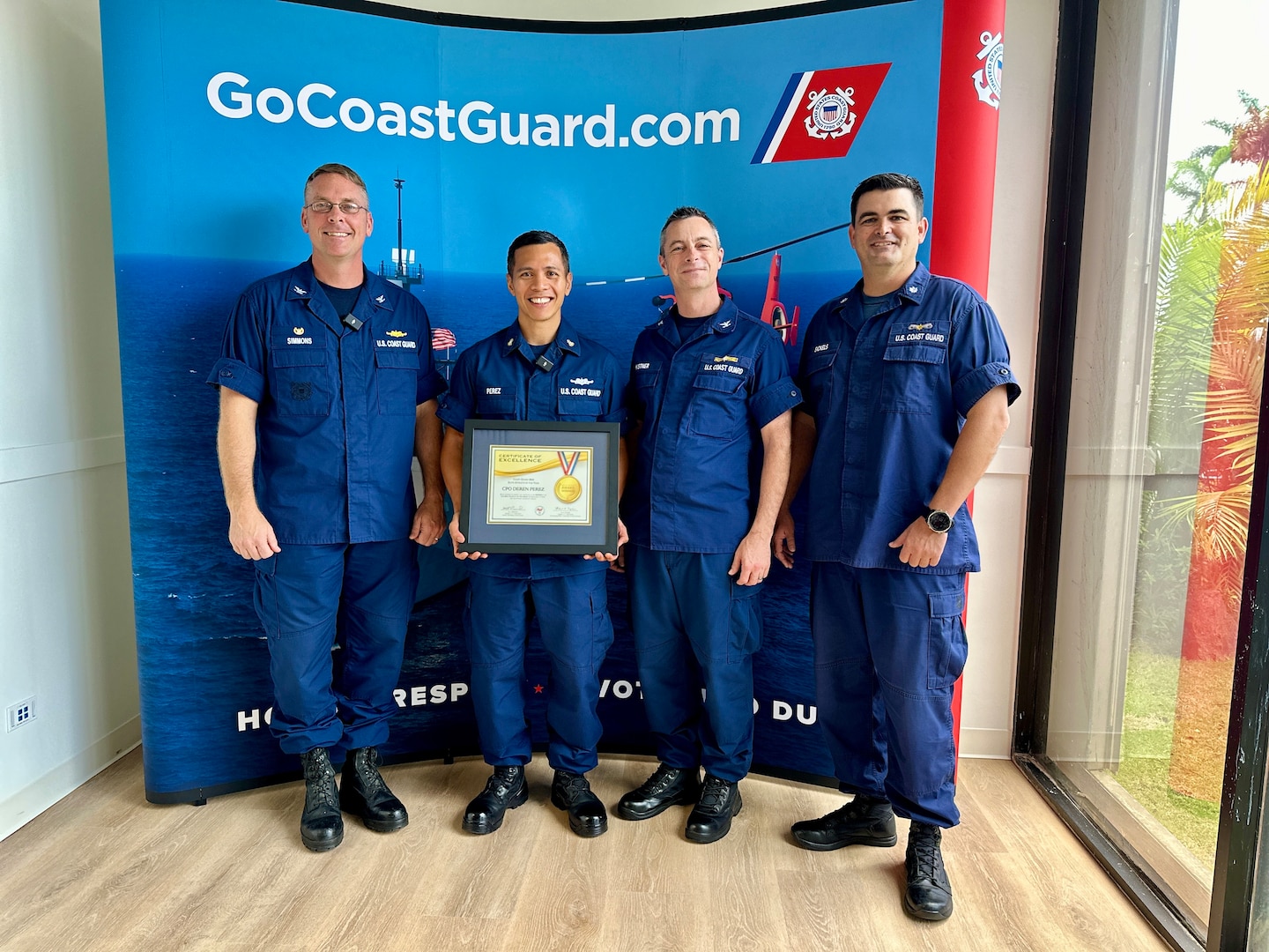 Chief Petty Officer Deren Perez, a figure of inspiration and leadership within the U.S. Coast Guard, is presented with the U.S. Coast Guard's Elite Male Athlete of the Year award by the U.S. Coast Guard Forces Micronesia Sector Guam command at the newly relocated recruiting office in Tamuning, Guam, on May 17, 2024. The award, presented on behalf of the U.S. Coast Guard MWR and the Community Services Command, is a testament to his exceptional athletic abilities and his unwavering dedication to his community. (U.S. Coast Guard photo by Chief Warrant Officer Sara Muir)
