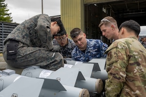 U.S. Air Force, Royal Australian Air Force, and Japan Air Self-Defense Force members construct munitions during a Combat Ammunition Production Exercise (CAPEX) at Misawa Air Base, Japan, May 8, 2024.