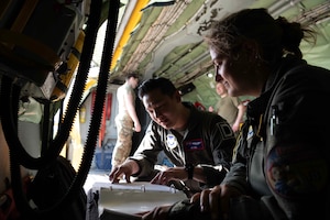 U.S. Air Force Capt. Audrey Springer, right, and Capt. Jeff Chae, 351st Air Refueling Squadron KC-135 Stratotanker pilots, review a pre-flight checklist on a KC-135 Stratotanker during the base readiness exercise Aw-R-Go at Royal Air Force Mildenhall, England, May 13, 2024.