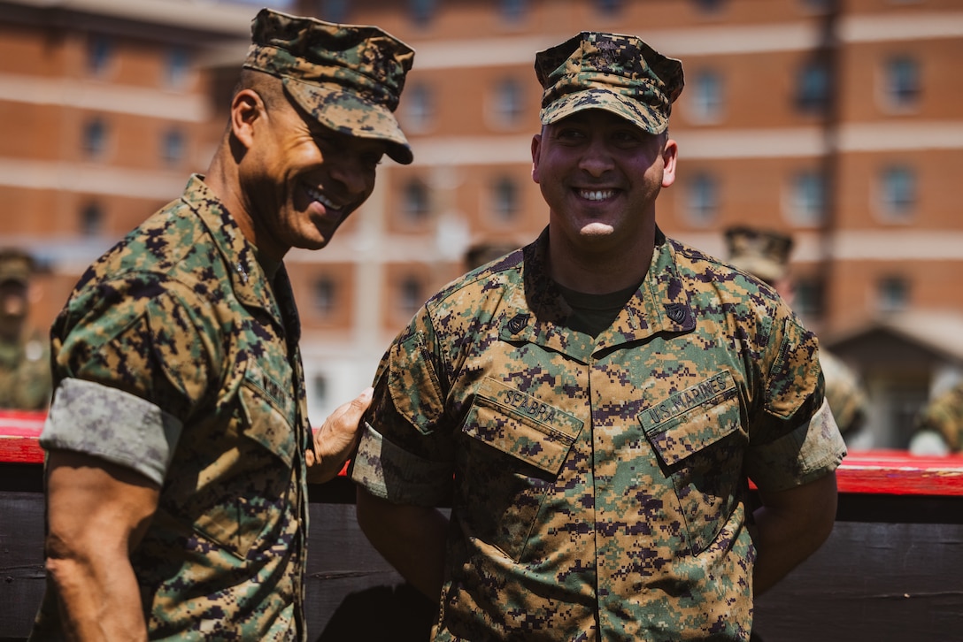 U.S. Marine Corps Maj. Gen. Calvert Worth Jr., left, the commanding general of 2d Marine Division (MARDIV), gives his remarks on Gunnery Sgt. Michael Seabra, right, a substance abuse control officer with Headquarters Battalion, 2d MARDIV, during a formation on Camp Lejeune, North Carolina, April 12, 2024. Worth held a formation to present challenge coins to Marines who embody the values of 2d MARDIV and consistently demonstrated the highest standard of leadership and professionalism. (U.S. Marine Corps photo by Cpl. Alexis Sanchez)