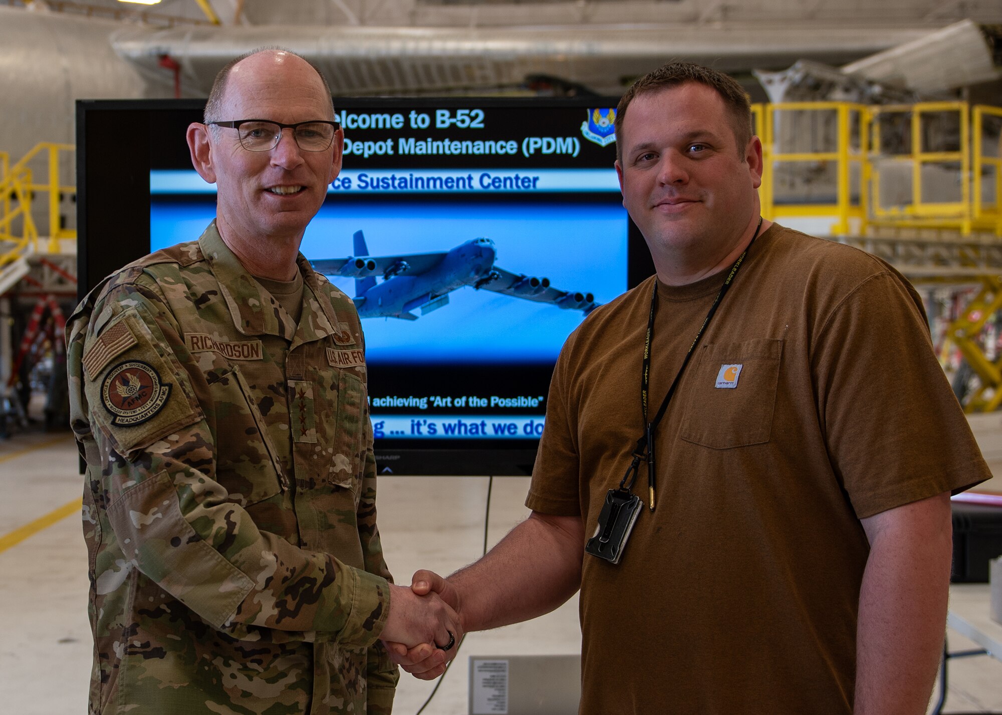 Two men standing together in front of TV