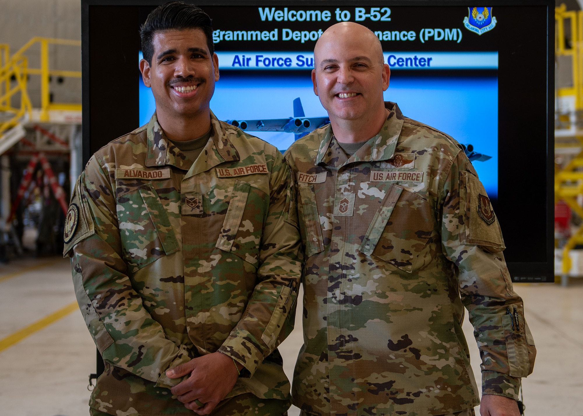 Two men standing together in front of TV