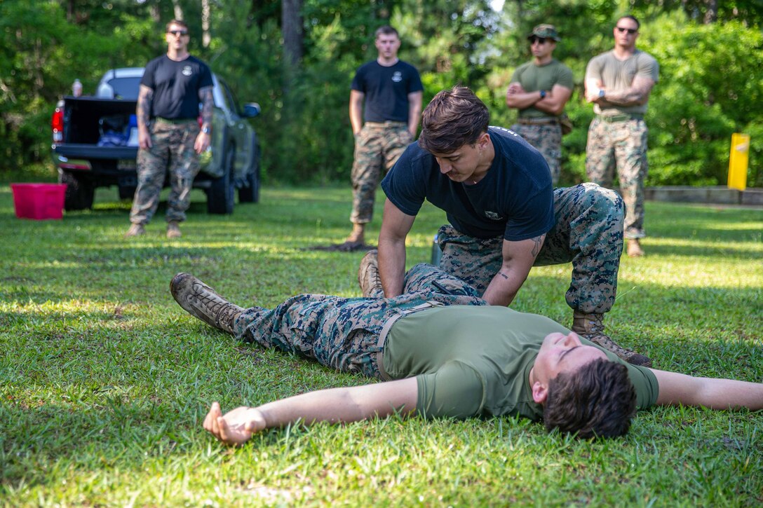 U.S. Navy Hospitalman Hunter Musgrave, with 2d Dental Battalion, 2nd Marine Logistics group, demonstrate how to apply a tourniquet during a Career Orientation Training for Midshipmen (CORTRAMID) on Camp Lejeune, North Carolina, May 17, 2024. The CORTRAMID program is a basic introduction and training event to familiarize U.S. Naval Academy Midshipmen with the primary warfare designators that they will serve in, along with providing them with exposure to what is often their first Marine Corps fleet experience. (U.S. Marine Corps photos by Lance Cpl. Christian Salazar)