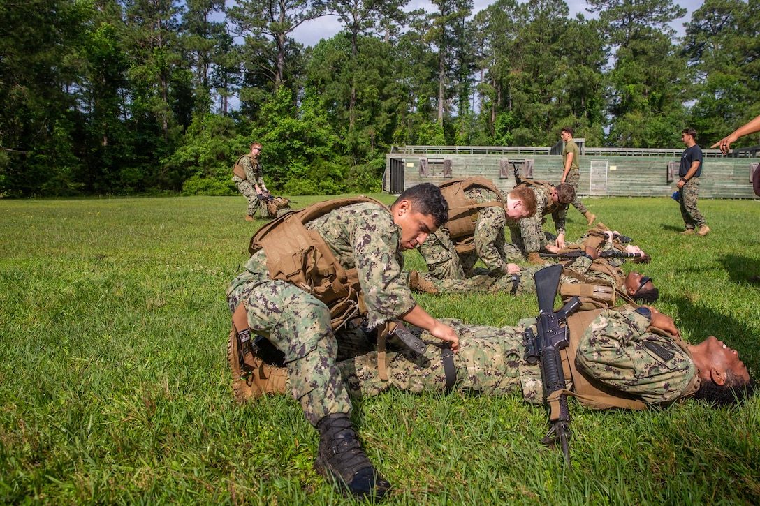 U.S. Naval Academy Midshipmen, conduct tactical combat casualty care, during a Career Orientation Training for Midshipmen (CORTRAMID) on Camp Lejeune, North Carolina, May 17, 2024. The CORTRAMID program is a basic introduction and training event to familiarize U.S. Naval Academy Midshipmen with the primary warfare designators that they will serve in, along with providing them with exposure to what is often their first Marine Corps fleet experience. (U.S. Marine Corps photos by Lance Cpl. Christian Salazar)