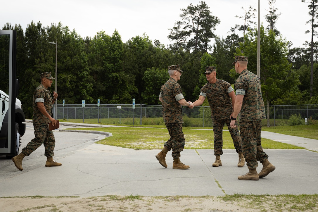 U.S. Marine Corps Gen. Christopher J. Mahoney, center, the assistant commandant of the Marine Corps (ACMC), shakes hands with Lt. Col. Brian Everett, commanding officer, Headquarters and Service Battalion, 2nd Marine Logistics Group (MLG), upon arrival to barracks building FC504 on Marine Corps Base (MCB) Camp Lejeune, North Carolina, May 14, 2024. The ACMC visited MCB Camp Lejeune to view current barracks living conditions and observe 2nd MLG and II Marine Expeditionary Force’s capabilities. (U.S. Marine Corps photo by Cpl. Antonino Mazzamuto)