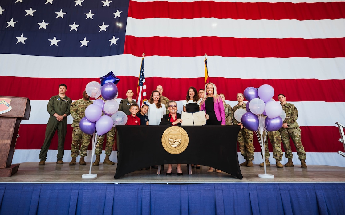 Arizona Governor Katie Hobbs and Luke Air Force Base members pose for a group photo with Arizona House Bill 2246 at a ceremonial signing.