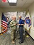 Male U.S. Army Medicine Recruiter poses with man in polo and slacks in front of the American Flag and the USAREC Flag