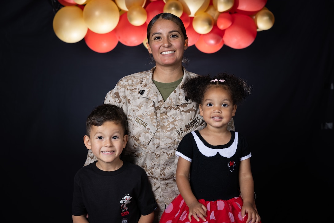 A Marine poses for a photo with her two kids.